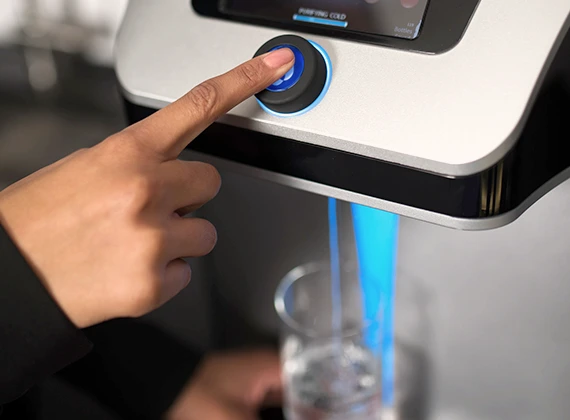 Primer plano de botón dispensador Culligan activado para servir agua filtrada
